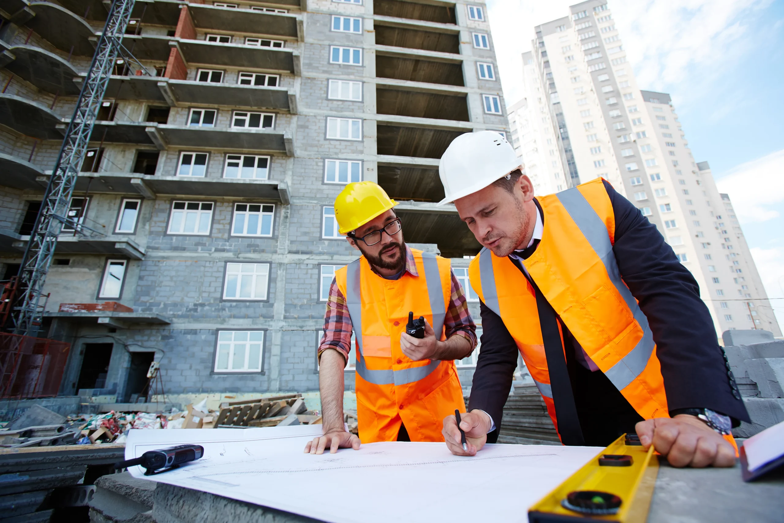 Construction accountants reviewing project plans and bookkeeping records